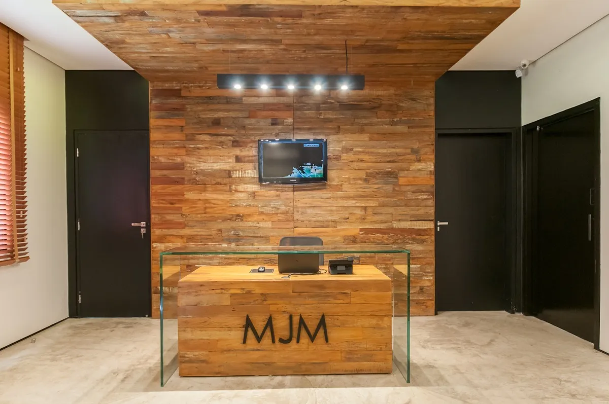 Recepção da sede da MJM, com o balcão e o logotipo